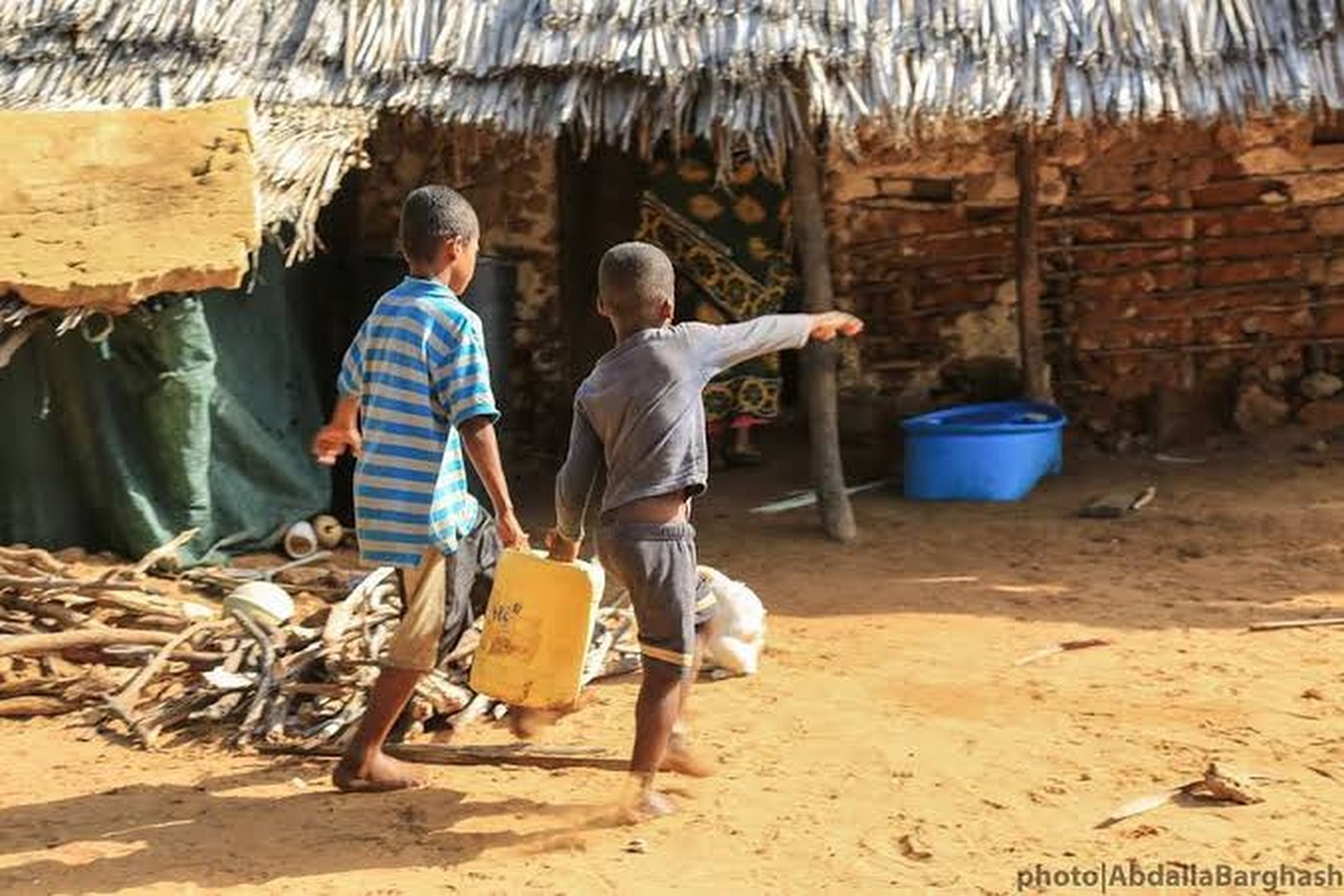 Children carrying a water container back to their home on Manda Island
